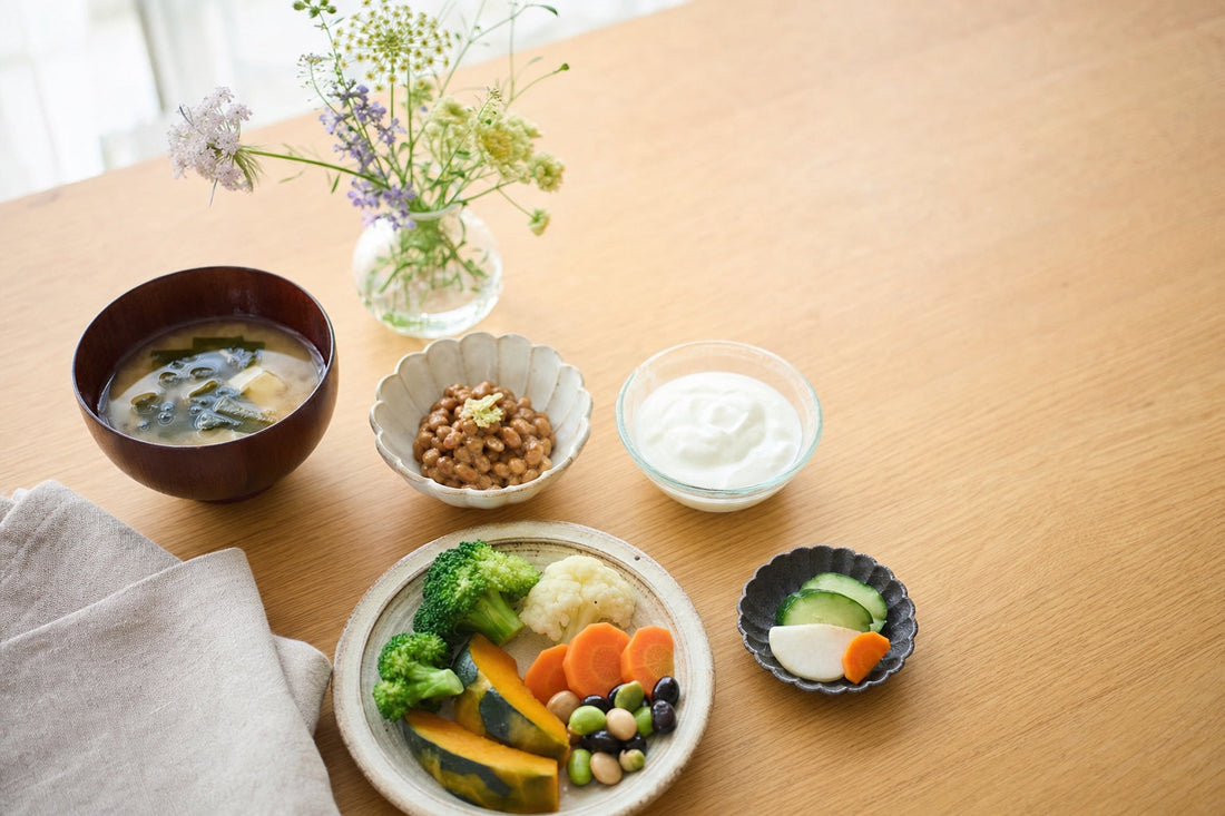 野菜や豆、みそ汁、ヨーグルトが並ぶ朝の食卓と、小さな花。腸内フローラ（お花畑）をテーマにした記事のアイキャッチ
